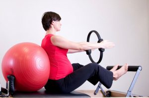 mujer sentada realizando ejercicio embarazada